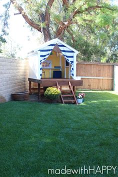 a small backyard with a picnic table in the middle and a blue and white striped tent