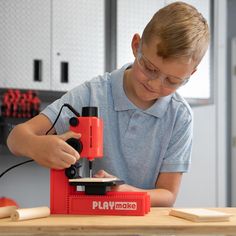 a young boy working with a sanding machine