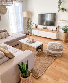 a living room filled with furniture and a flat screen tv on top of a wooden table