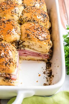 ham and cheese sliders in a casserole dish with parsley sprinkled on top