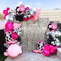 the balloon arch is decorated with pink, black and white balloons