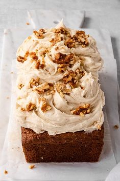 a loaf of cake with frosting and nuts on top