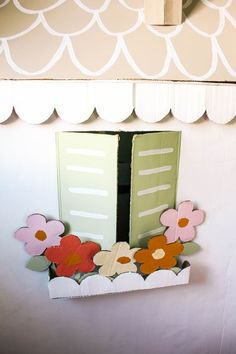 an open window with paper flowers in it