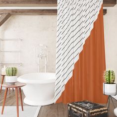 a bathroom with an orange shower curtain and white bathtub next to a wooden table