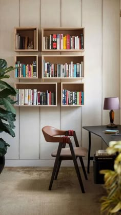 a living room filled with furniture and bookshelves next to a plant in a pot