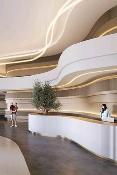 two people are standing at the counter in an office building with curved ceilings and white walls