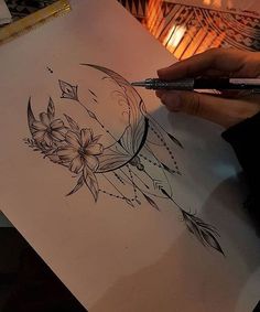 a person drawing on paper with a pen