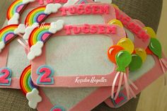 there are three pink frames with numbers and rainbows on the top one is for two children