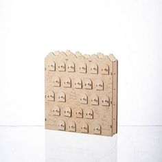 a wooden block with many holes in it on a white surface and one piece is missing