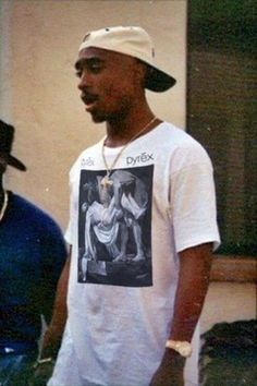 two black men standing next to each other in front of a building with a poster on it