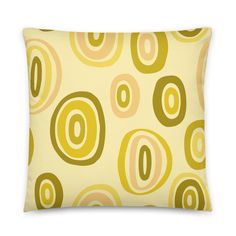 a pillow with circles on it in yellow and brown colors, sitting against a white background