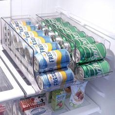 an open refrigerator with cans of soda and soft drinks