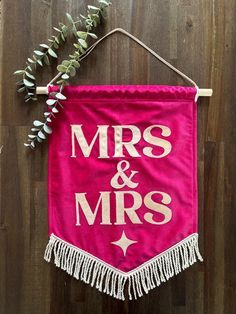 a pink banner with the words mrs and mr's hanging on a wooden wall