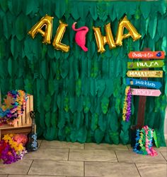 there is a sign that says aloha next to a bench with flowers on it