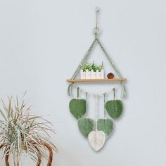 a potted plant sitting on top of a wooden shelf next to a wall hanging