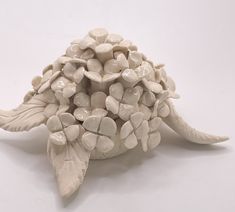 a white ceramic turtle sculpture sitting on top of a table