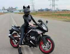 a woman sitting on top of a black motorcycle