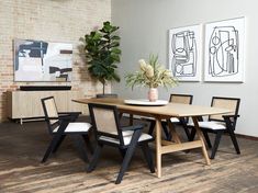 a dining room table with four chairs and a potted plant in the center on top