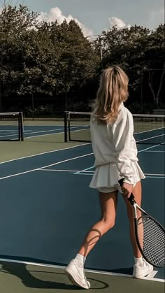 a woman standing on top of a tennis court holding a racquet in her hand