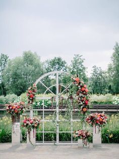 an outdoor ceremony setup with flowers and greenery