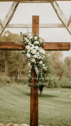 a cross decorated with flowers and greenery