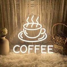 a coffee cup neon sign sitting on top of a white fluffy rug next to a vase