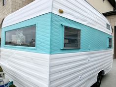 a blue and white trailer parked in front of a building