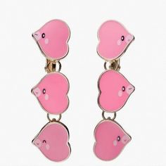 two pink piggy earrings are hanging from the back of a pair of ear clips