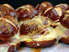 several hot dogs covered in cheese and ham