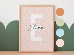 there is a framed photo with the letter e on it next to polka dot wallpaper