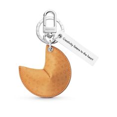 a keychain with a wooden crescent shaped object attached to it's side