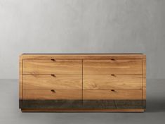 a large wooden dresser sitting on top of a cement floor next to a white wall