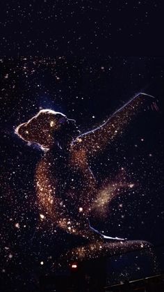 the silhouette of a person is projected in the dark with stars all over them and on their body