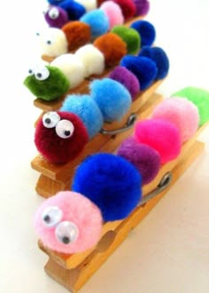 a group of small toy animals sitting on top of a wooden rack with eyes and noses