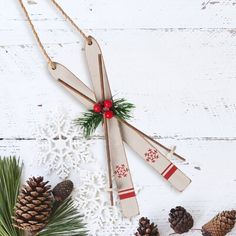 some pine cones and snowflakes on a white wooden table with twine needles