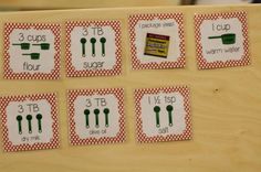 four place cards with green utensils on them and the numbers for each individual item