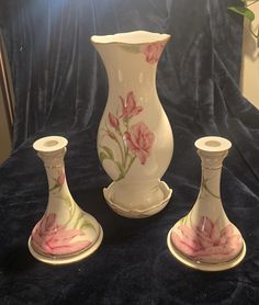 three white vases with pink flowers painted on them