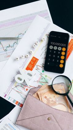 a calculator, magnifying glass, money and other items on a table