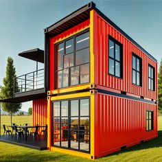 a red and yellow container house sitting on top of a lush green field