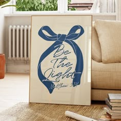 a framed poster with a blue ribbon on it sitting in front of a couch next to a window