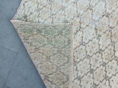 two different rugs on the ground, one is grey and white with green accents