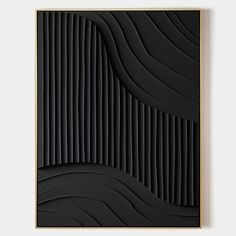 an abstract black and gold art piece with wavy lines in the center, on a white wall