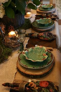 the table is set with green plates and place settings