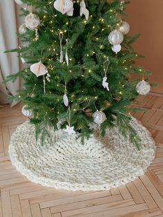 a small christmas tree with white ornaments on the top and green needles in front of it