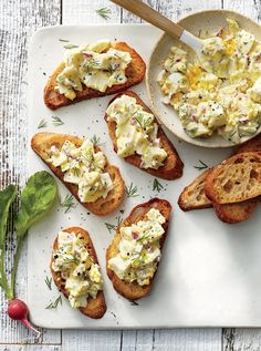 several pieces of bread with different types of food on them and a bowl of dip