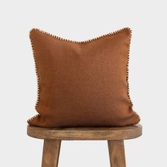 a brown pillow sitting on top of a wooden stool