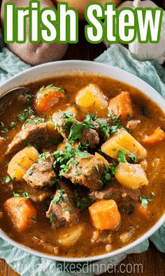 a bowl of irish stew with potatoes and carrots in it on a wooden table