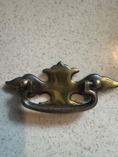 an antique brass door handle on a white counter