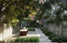 an outdoor courtyard with benches and trees in the foreground, surrounded by brick walls