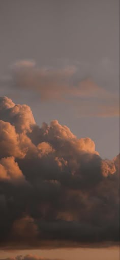 an airplane is flying through the clouds at sunset